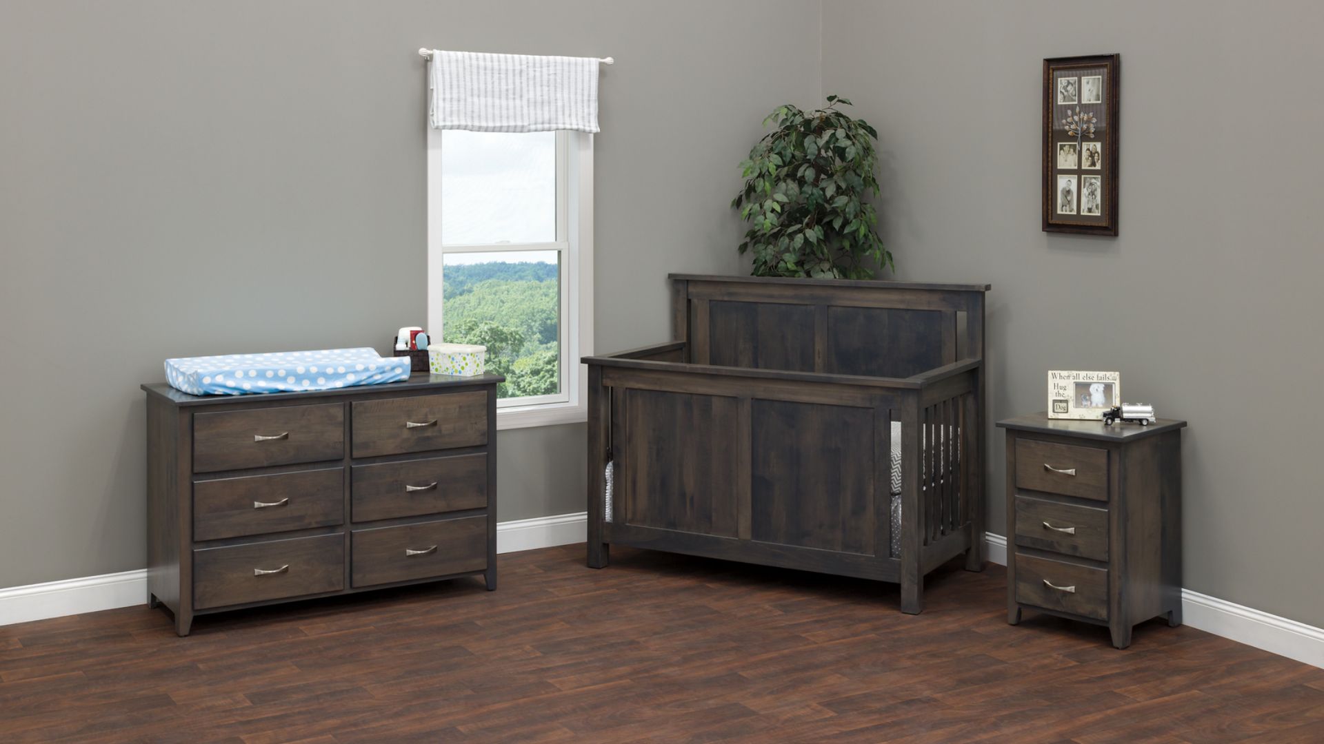 A wooden crib and dresser in a nursery with a window and plant.