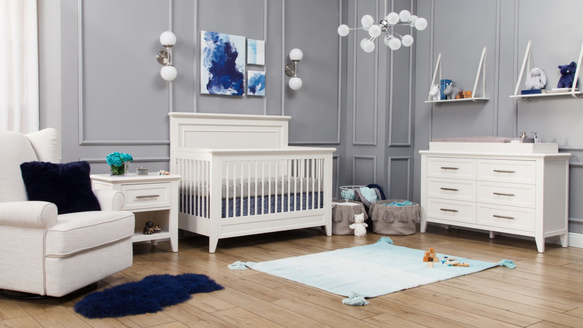 A modern white nursery with crib and blue accents.